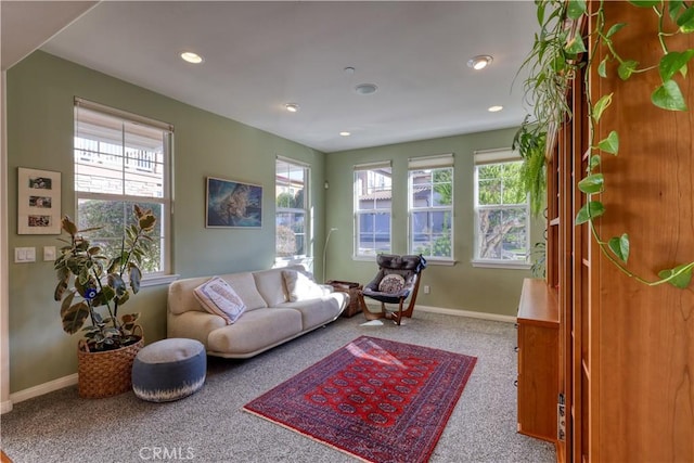 living room featuring baseboards, carpet floors, and a healthy amount of sunlight