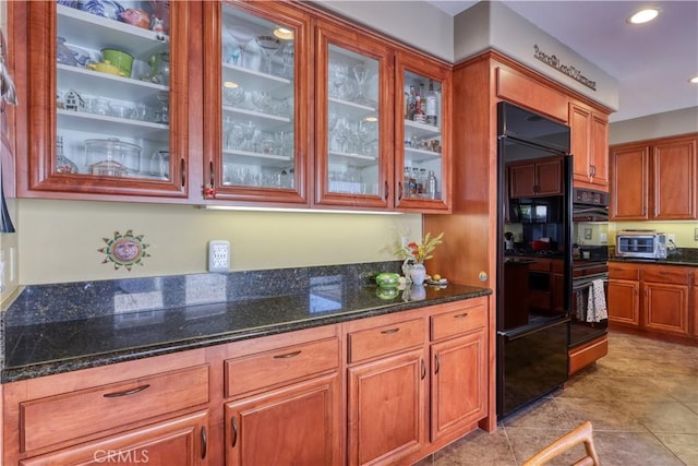 kitchen with double wall oven and dark stone counters