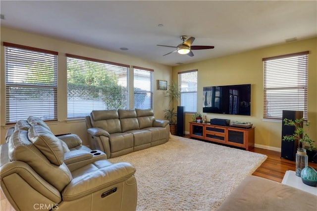 living room with ceiling fan, light wood finished floors, and baseboards