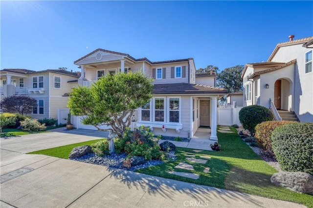 view of front of property featuring concrete driveway, a tile roof, and fence