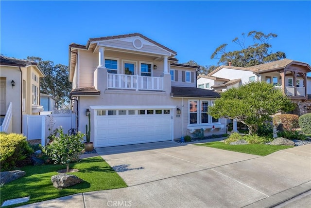 view of front of house featuring a balcony, driveway, an attached garage, and a tiled roof