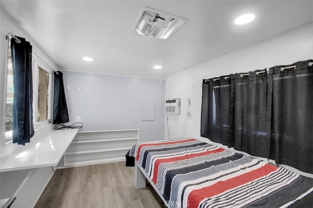 bedroom with hardwood / wood-style floors and a wall mounted air conditioner