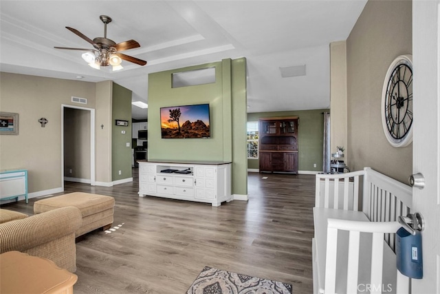 living room with ceiling fan, hardwood / wood-style floors, and a raised ceiling