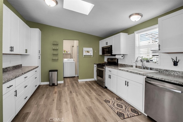 kitchen with sink, white cabinets, stainless steel appliances, and washer / clothes dryer