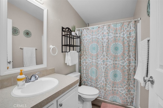 bathroom with toilet, vanity, and walk in shower