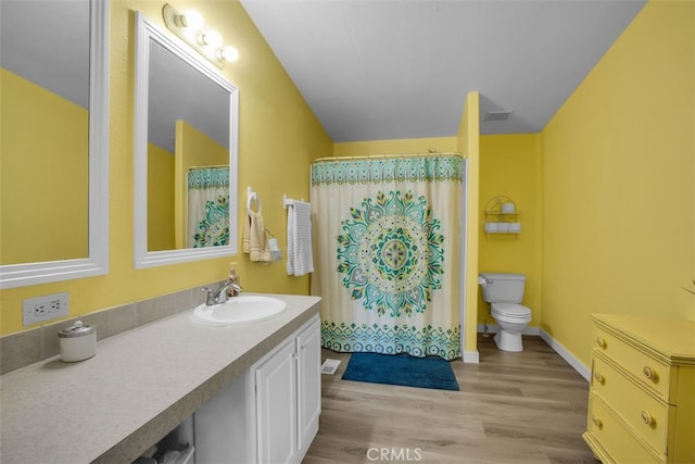 bathroom with hardwood / wood-style flooring, curtained shower, toilet, and vanity