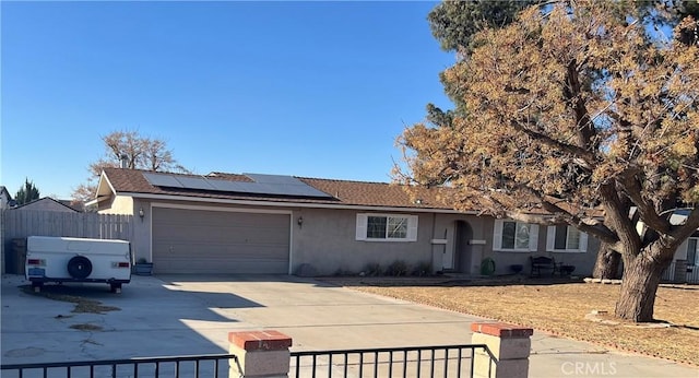 ranch-style house with a garage and solar panels