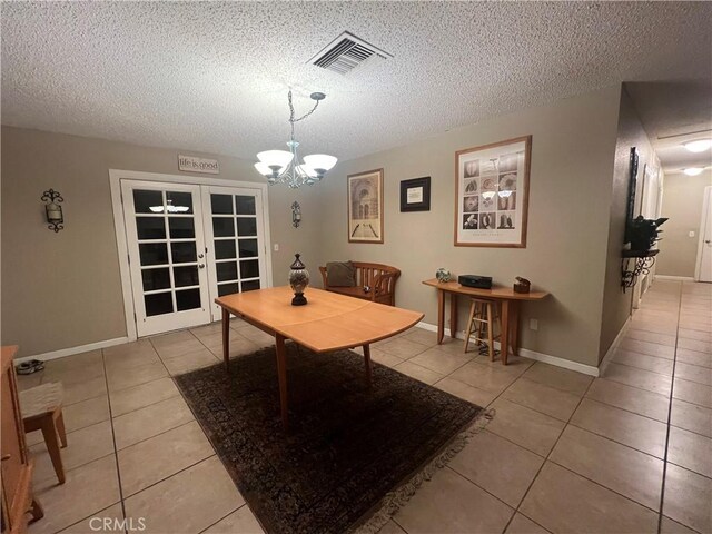 dining room with light tile patterned floors, a chandelier, and a textured ceiling