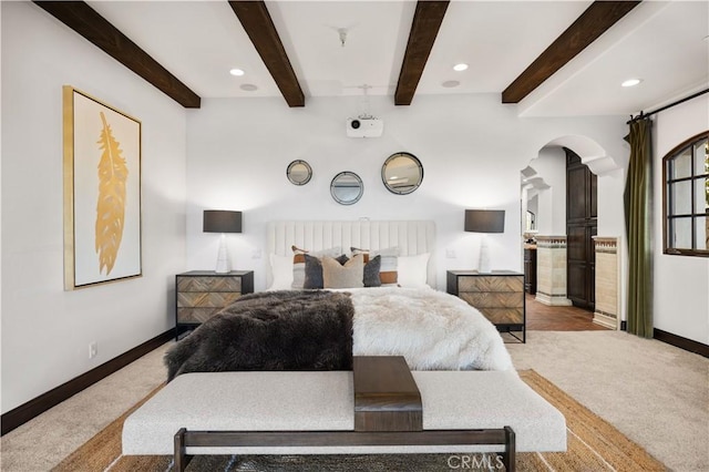 bedroom featuring light carpet and beam ceiling