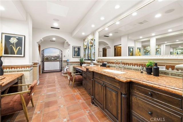 bathroom featuring vanity, tile patterned flooring, and tile walls