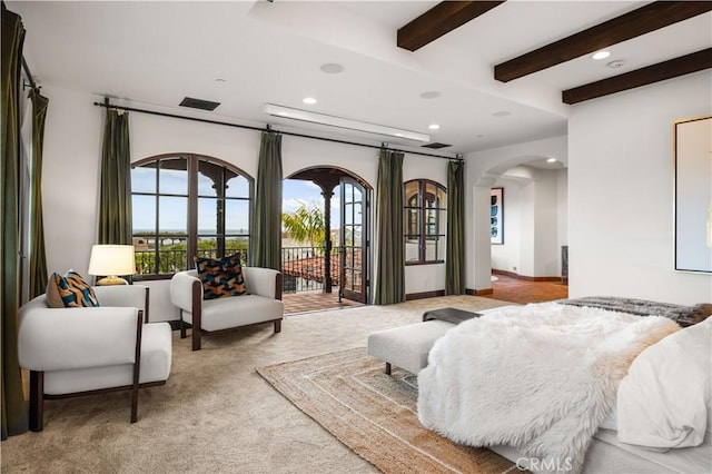 carpeted bedroom with beam ceiling and access to outside