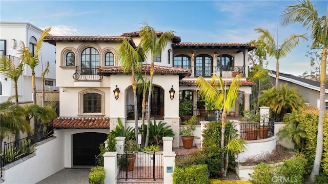 mediterranean / spanish-style home featuring a garage and a balcony