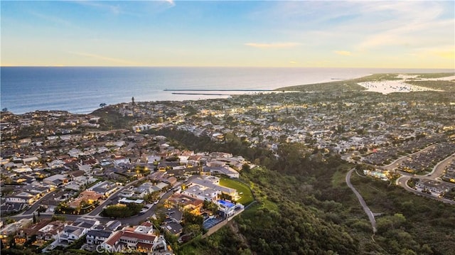 aerial view at dusk featuring a water view