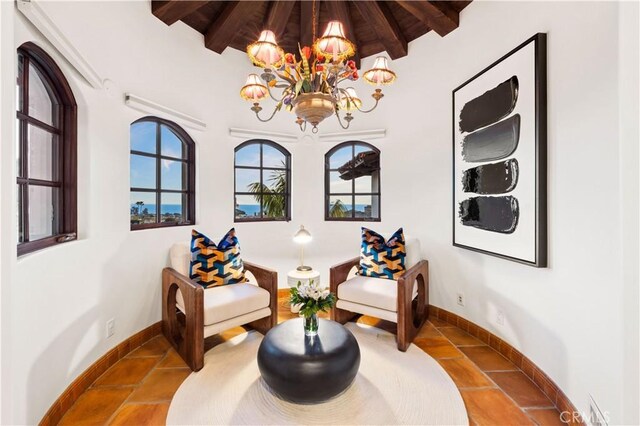 living area featuring lofted ceiling with beams, tile patterned floors, an inviting chandelier, and wooden ceiling