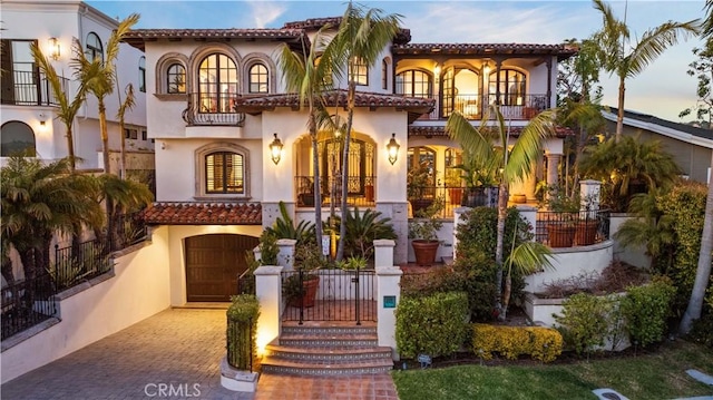 mediterranean / spanish house with a garage and a balcony