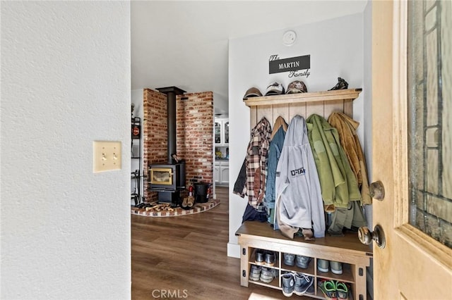 mudroom with wood-type flooring and a wood stove