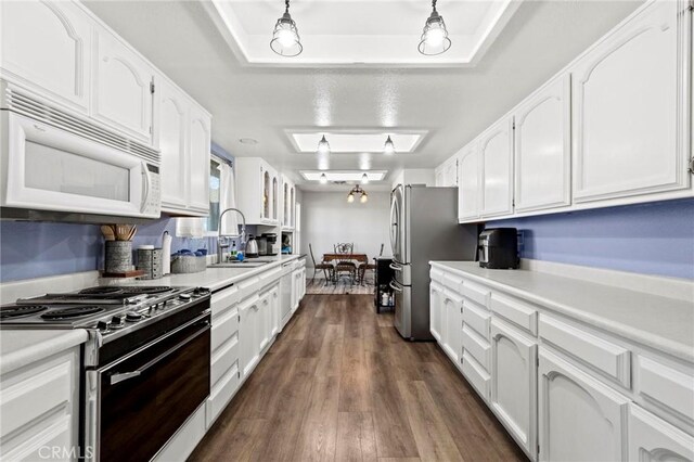 kitchen featuring stove, sink, and white cabinetry
