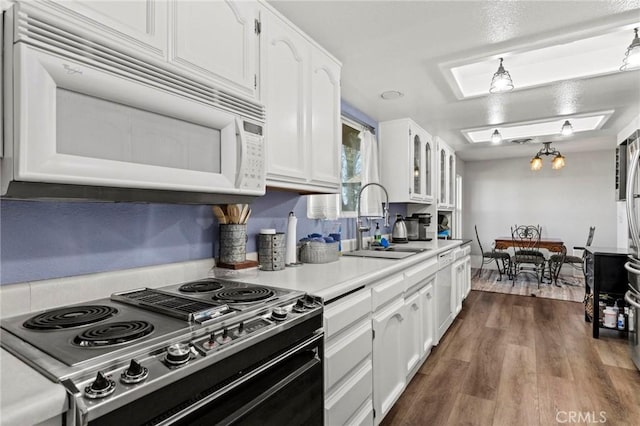 kitchen with white appliances, dark hardwood / wood-style flooring, sink, and white cabinets
