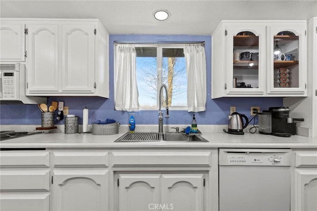 kitchen with sink, white appliances, and white cabinets