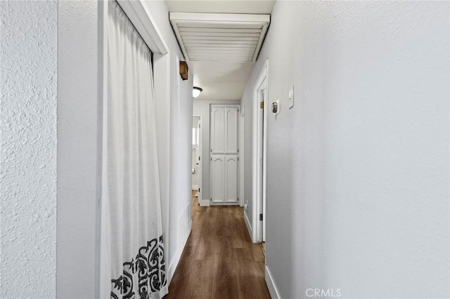 corridor with dark hardwood / wood-style flooring