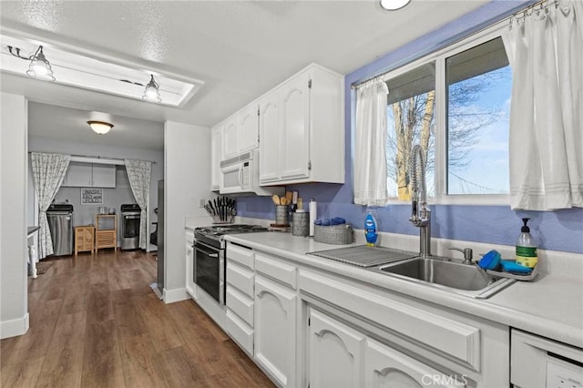 kitchen featuring electric stove, sink, dark wood-type flooring, stainless steel range, and white cabinets