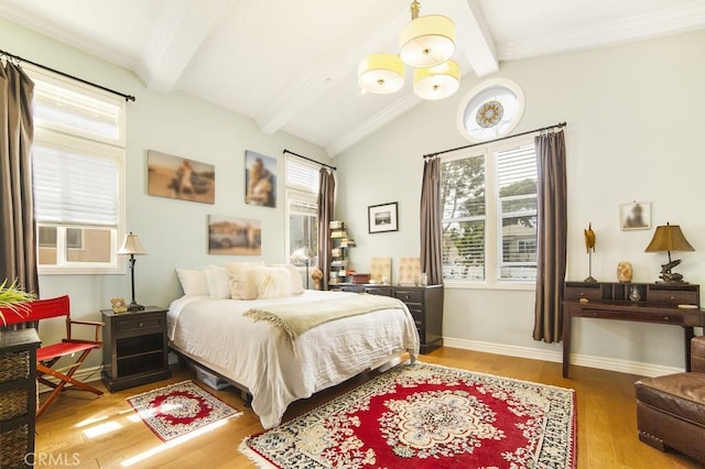 bedroom with multiple windows, vaulted ceiling with beams, light wood-style flooring, and baseboards