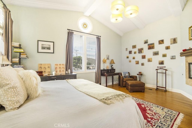 bedroom with a fireplace, visible vents, lofted ceiling with beams, wood finished floors, and baseboards