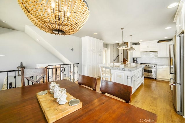 dining space with wood finished floors and recessed lighting