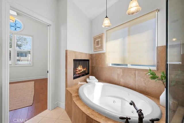1612 Speyer Ln, Redondo Beach, CA 90278 - full bathroom with a tub with jets, lofted ceiling, a glass covered fireplace, and tile patterned flooring