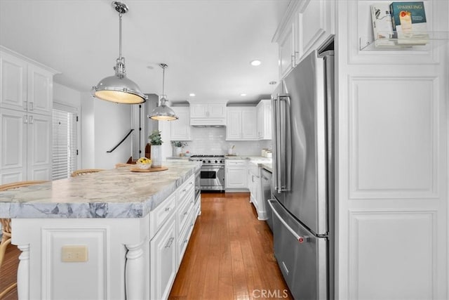 1612 Speyer Ln, Redondo Beach, CA 90278 - kitchen with premium appliances, white cabinetry, tasteful backsplash, a kitchen island, and recessed lighting
