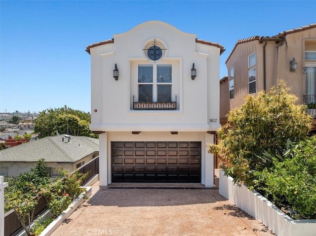 1612 Speyer Ln, Redondo Beach, CA 90278 - mediterranean / spanish home featuring a garage, stucco siding, and decorative driveway