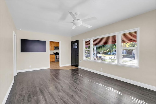 unfurnished living room featuring ceiling fan, a healthy amount of sunlight, and dark hardwood / wood-style floors