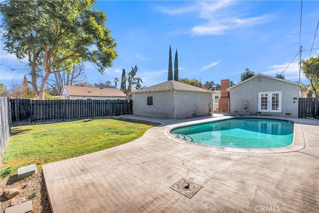 view of swimming pool featuring a patio area, a yard, and french doors