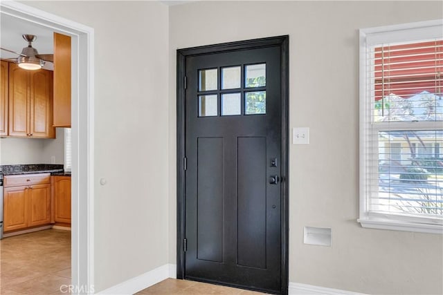 tiled entryway featuring ceiling fan