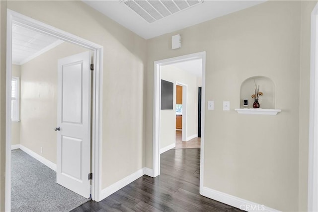 hall with dark hardwood / wood-style floors and crown molding