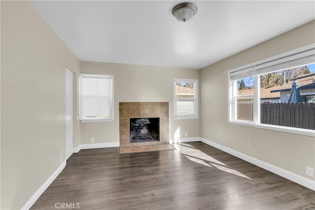 unfurnished living room with dark wood-type flooring and a fireplace