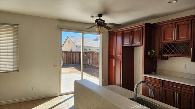 kitchen with ceiling fan, light tile patterned flooring, and sink