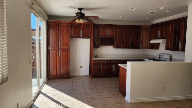 kitchen with ceiling fan, light tile patterned floors, and stove