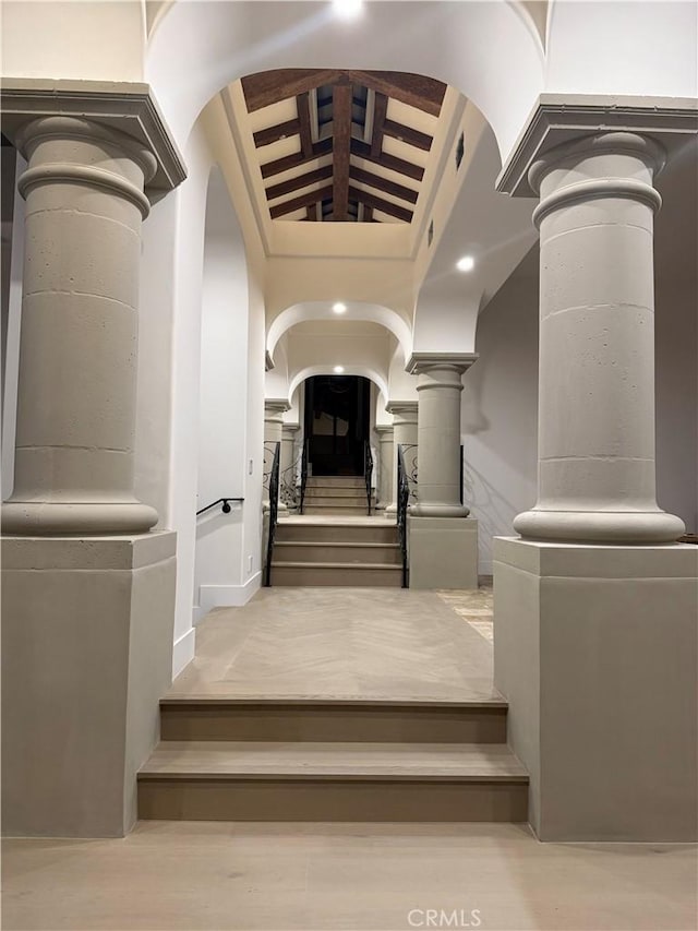 stairs featuring lofted ceiling with beams and decorative columns