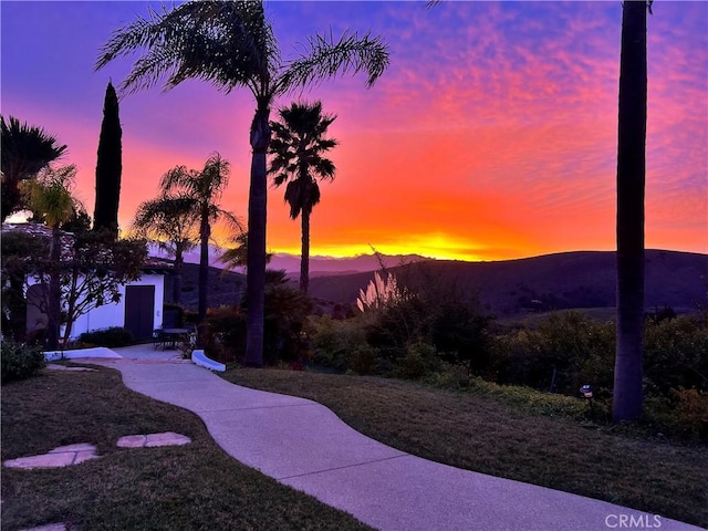 yard at dusk featuring a mountain view and a patio