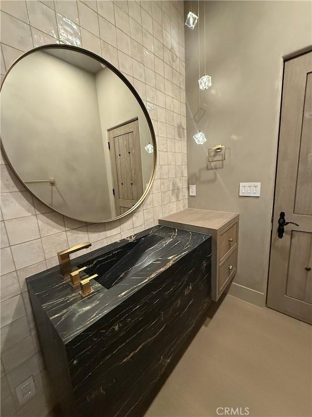 bathroom featuring vanity and tile walls