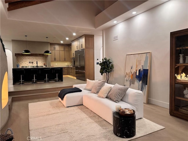 living room with baseboards, light wood-style flooring, visible vents, and recessed lighting