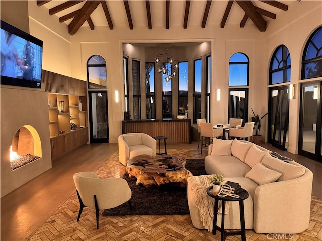 living area featuring built in shelves, a high ceiling, and beamed ceiling