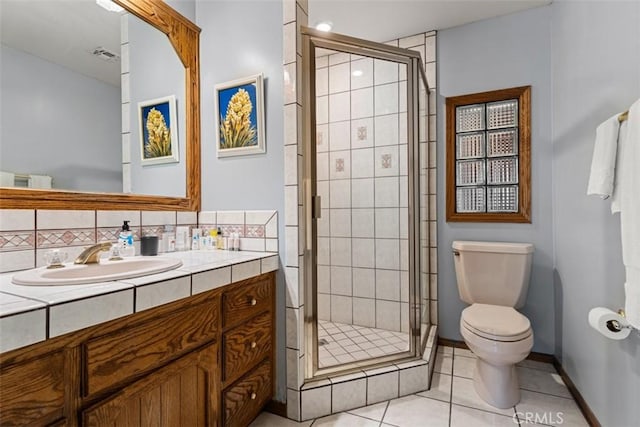 bathroom featuring toilet, tasteful backsplash, tile patterned floors, walk in shower, and vanity