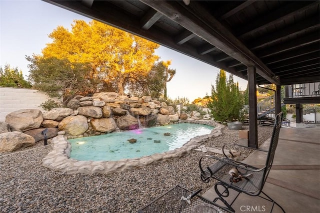 view of swimming pool with pool water feature and a patio