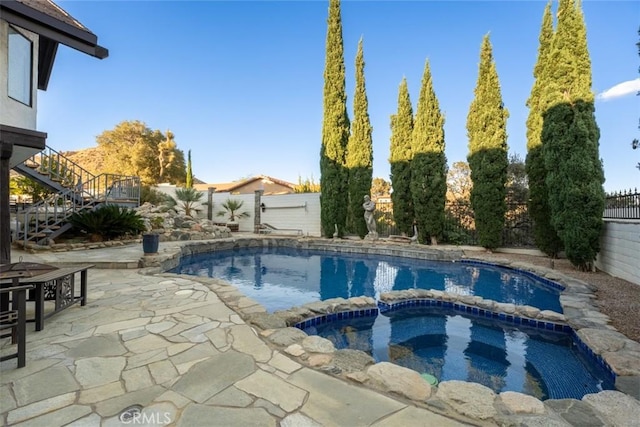 view of swimming pool featuring a patio and an in ground hot tub