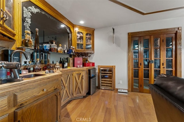 bar with beverage cooler, french doors, sink, stainless steel fridge, and light wood-type flooring