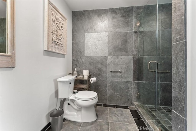 bathroom with a shower with shower door, tile patterned floors, and toilet