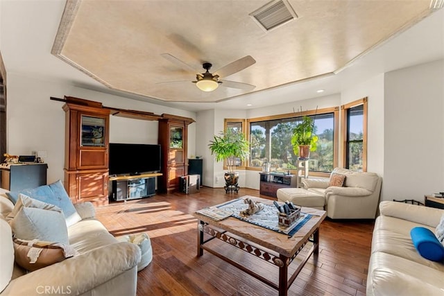 living room featuring ceiling fan and dark hardwood / wood-style flooring