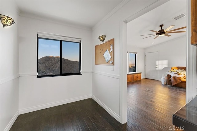 spare room with ceiling fan, dark wood-type flooring, and crown molding